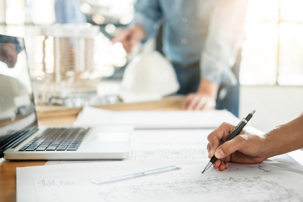 Close up,Of,Person's,Engineer,Hand,Drawing,Plan,On,Blue,Print